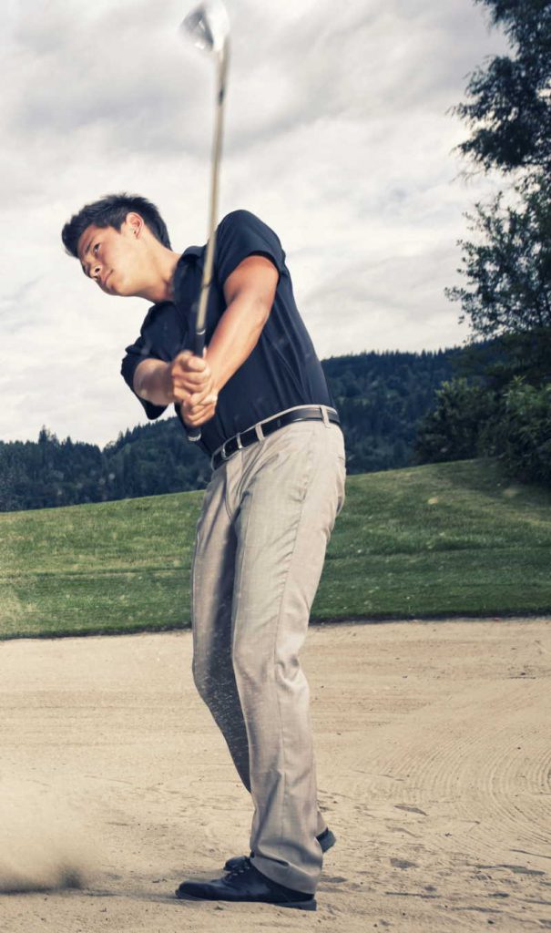 Player in a sand trap hitting with an iron
