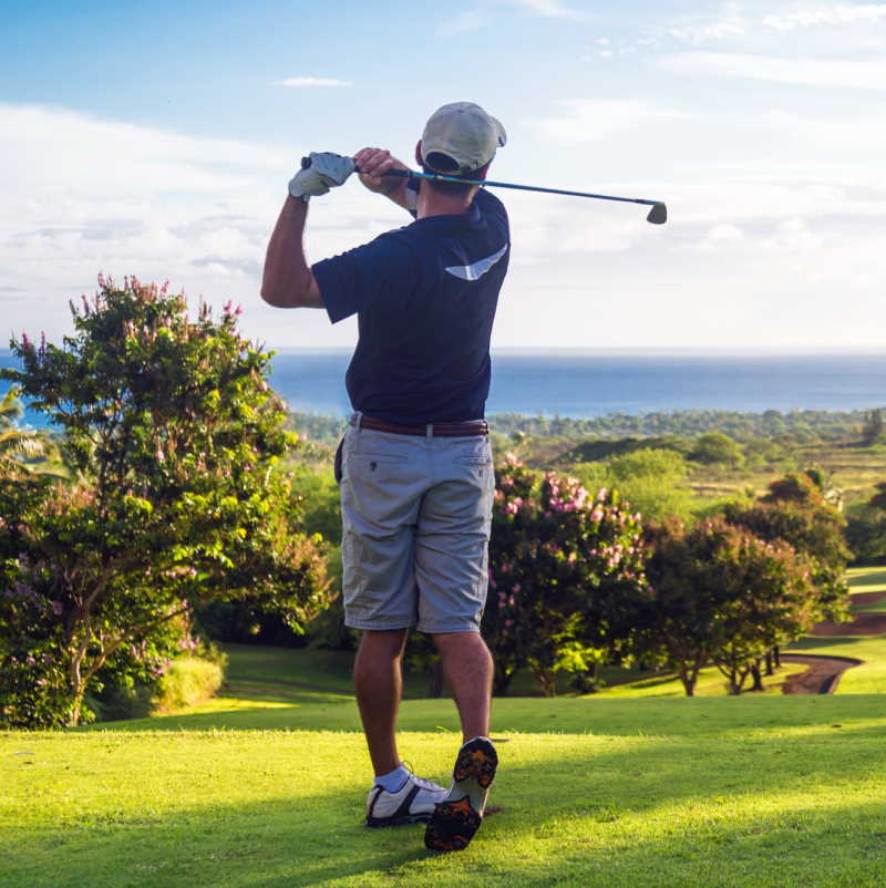 golfer hitting a ball with a golf iron
