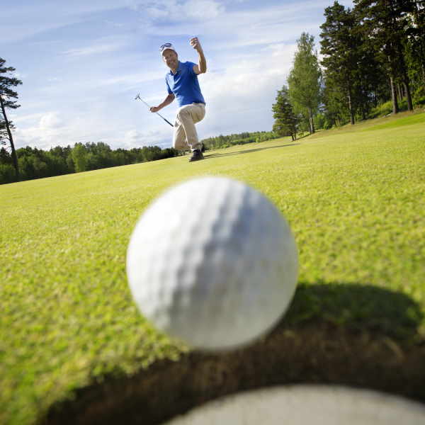 golf ball going into a hole on the green