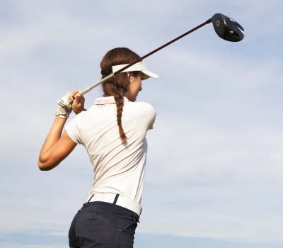lady swinging a golf driver