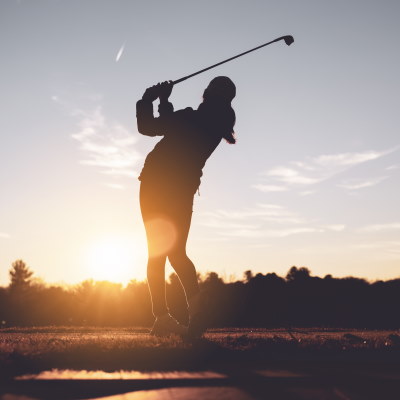 women's driver - ladie golfer hitting a shot in the sunset