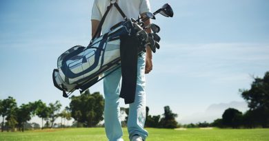 Golf man walking with shoulder bag on course in fairway