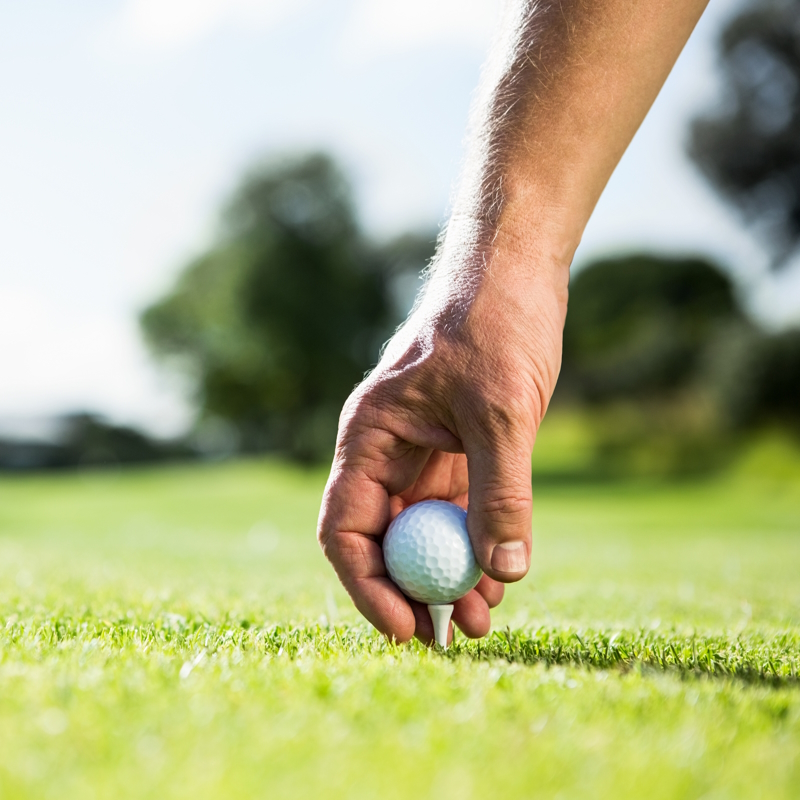 teeing up a golf ball on the golf course