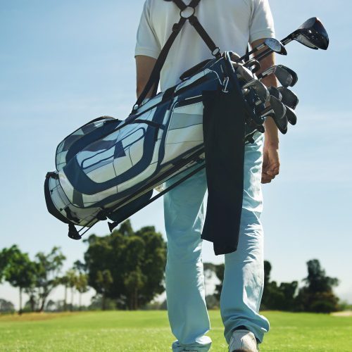 Golf man walking with shoulder bag on course in fairway - 14-Club Limit in golf