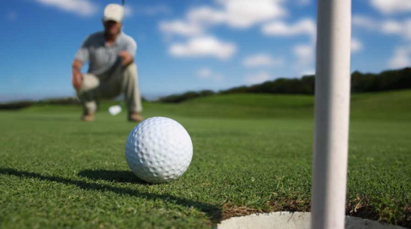golf ball on the green near the hole