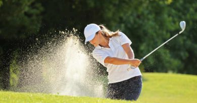 female golfer using irons in a sand trap