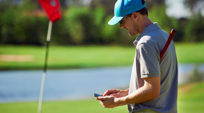 man using golf gps on the golf course - blog feature image